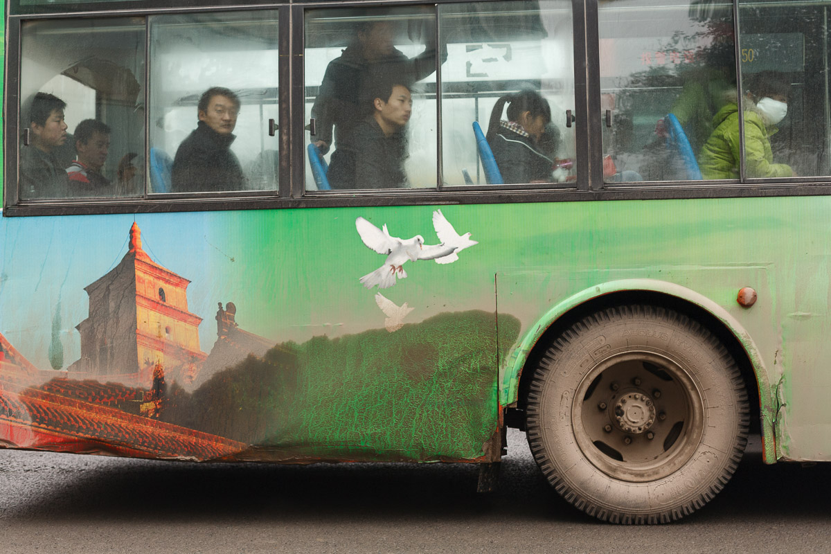 The dirty side of bus in Xian, China, depicting the Great Wall of China.